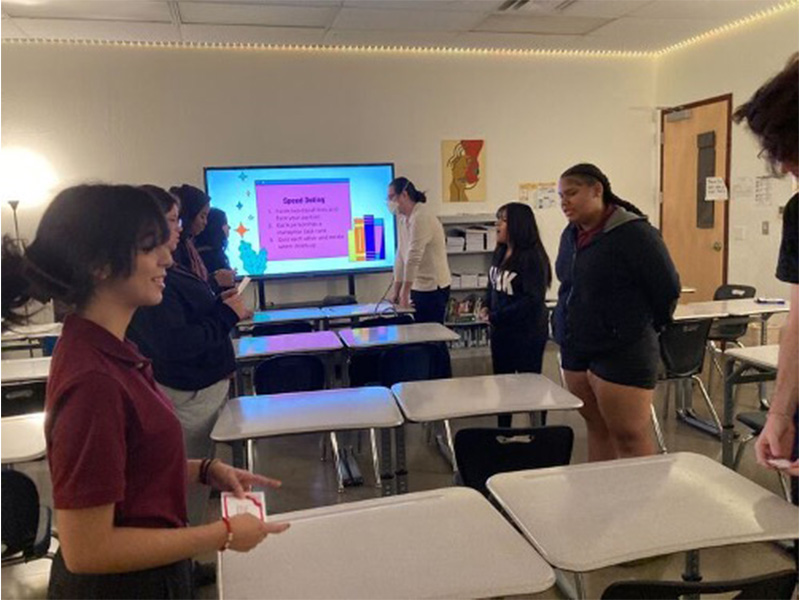 Students stand across from each other and do a spoken activity